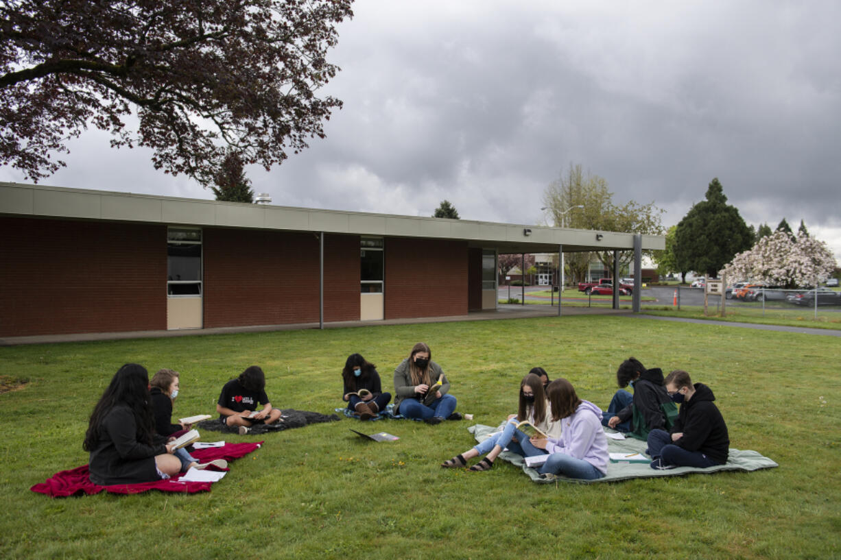 Eighth-graders gather outside on blankets while taking part in an English class with student teacher Megan Collins at Laurin Middle School on Monday morning, April 26, 2021.(Amanda Cowan/The Columbian)