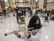 Seventh grader Valyssa Nguyen wears a specialized band mask and a cover on the end of her flute for COVID-19 protections during band class Monday morning at Laurin Middle School.