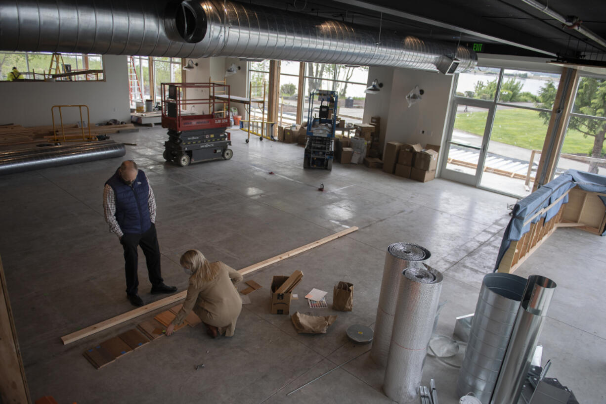 George Goodrich, left, and his daughter, Gwen, look over samples of booth material for the Cove Restaurant. The Cove announced plans to open as the first commercial business at Tidewater Cove on the Columbia River.