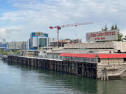 New development along the Vancouver waterfront rises behind the former Red Lion Hotel at the Quay on Wednesday morning. The Washington Legislature has provided $1 million to demolish the landmark building as part of the Port of Vancouver's Terminal 1 redevelopment project.