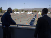 Second Gentleman Douglas Emhoff, right, and Governor Jay Inslee, left, look out over the mass vaccination site at State Fair Park during the coronavirus pandemic Tuesday, April 6, 2021 in Yakima, Wash.