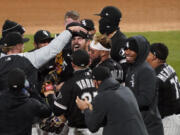 Chicago White Sox starting pitcher Carlos Rodon, center, celebrates his no hitter against the Cleveland Indians with his teammates in a baseball game, Wednesday, April, 14, 2021, in Chicago.