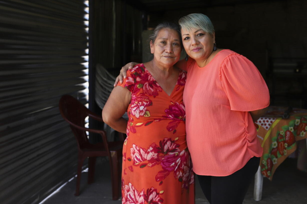 Iris Franco, right, hugs her mother, Elsa Victorina Franco, at her home, in El Ranchador, Santa Ana, El Salvador, Friday, March 5, 2021. The Salvadoran family lives humbly but is in a better place thanks to financial support from a family member in the United States who is part of the Temporary Protected Status program.