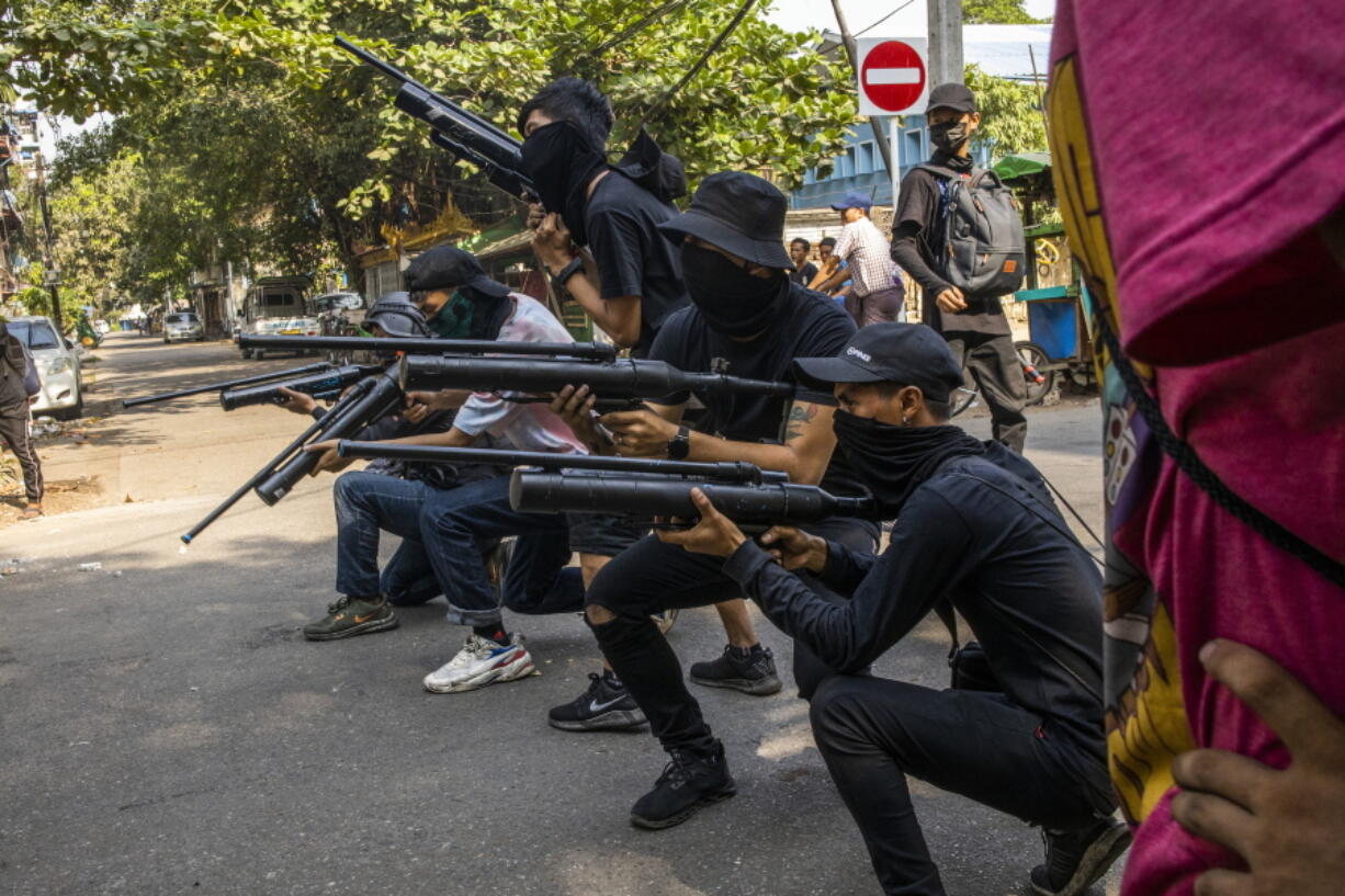 Anti-coup protesters line in formation with homemade air rifles during a demonstration against the military coup in Yangon, Myanmar, Saturday, April 3, 2021.