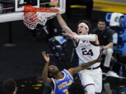 Gonzaga forward Corey Kispert (24) dunks the ball over UCLA guard David Singleton, left, during the second half of Saturday&#039;s NCAA semifinal in Indianapolis.