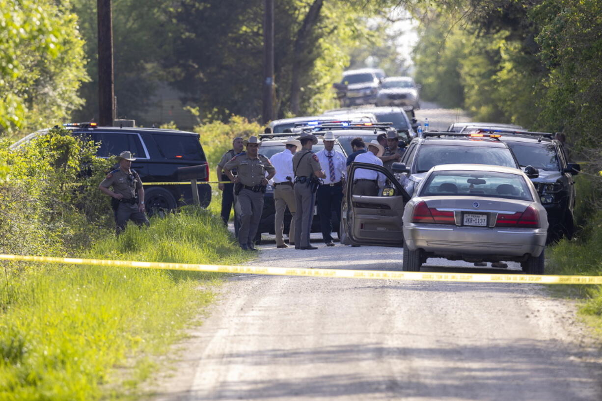 First responders work at the scene of the apprehension of a suspect at a residence in Bedias, Texas, Thursday, April 8, 2021, following a shooting at Kent Moore Cabinets in Bryan, Texas. One person was killed and several people were wounded Thursday in the wake of a shooting at the cabinet-making business in Bryan, authorities said, and a state trooper was later shot during a manhunt that resulted in the suspected shooter being taken into custody.