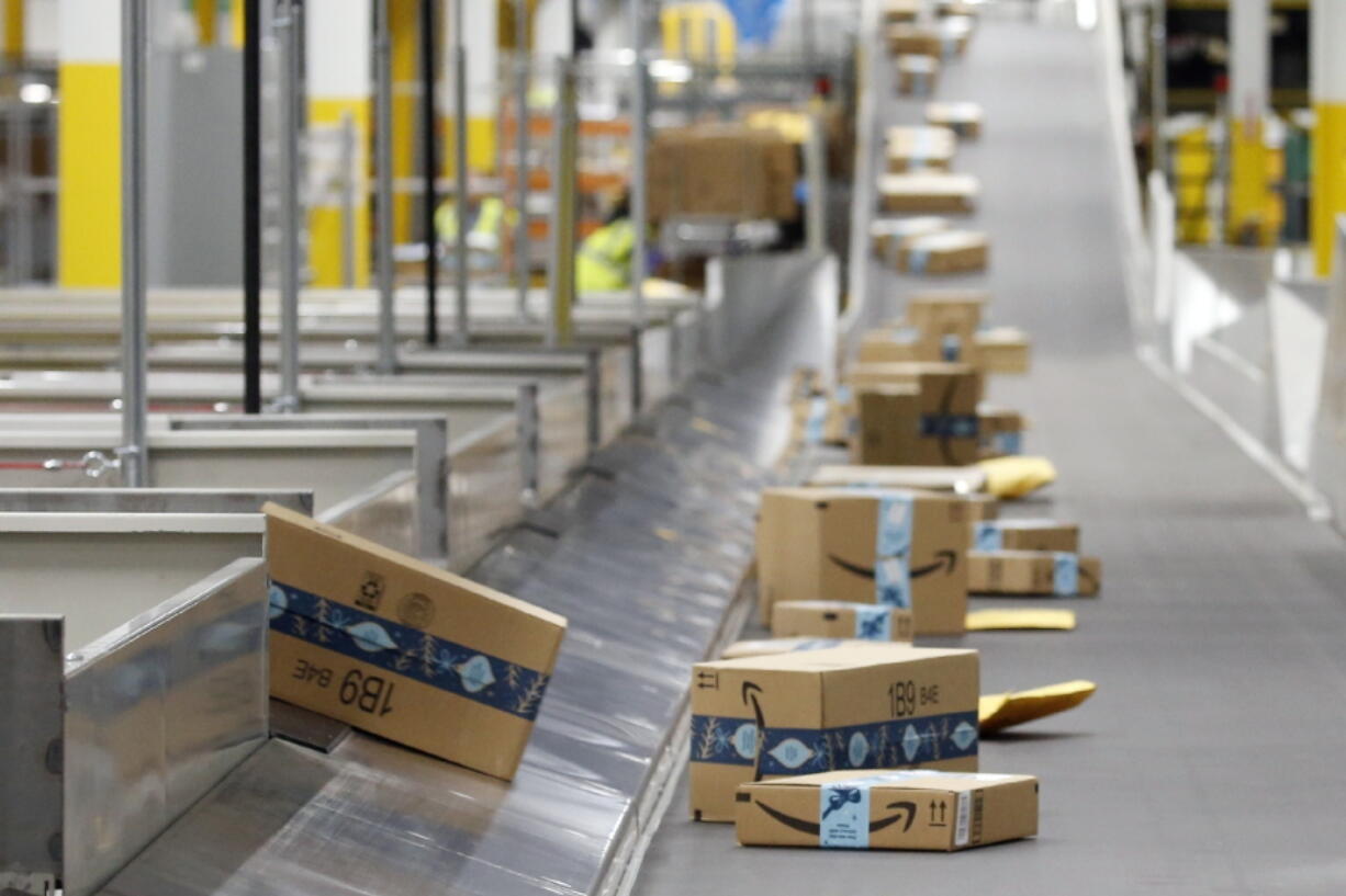 FILE - In this Dec. 17, 2019, file photo, Amazon packages move along a conveyor at an Amazon warehouse facility in Goodyear, Ariz. Amazon's pandemic boom isn't showing signs of slowing down. The company said Thursday, April 29, 2021, that its first-quarter profit more than tripled from a year ago, fueled by the growth of online shopping. It also posted revenue of more than $100 billion, the second quarter in row that the company has passed that milestone. (AP Photo/Ross D.