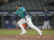 Seattle Mariners' Dylan Moore watches his RBI single during the third inning of the team's baseball game against the Los Angeles Angels, Friday, April 30, 2021, in Seattle. (AP Photo/Ted S.