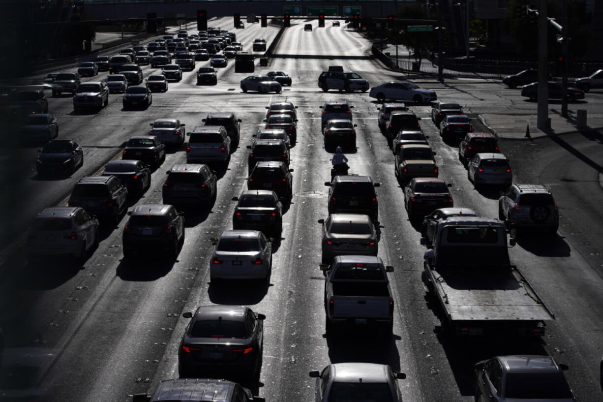 FILE - In this Thursday, April 22, 2021, file photo, cars wait at a red light during rush hour at the Las Vegas Strip, in Las Vegas. The trade association representing most major automakers is offering guidelines for manufacturers to advertise partially automated driving systems and make sure drivers are paying attention while using them. The Alliance for Automotive Innovation says its members support the voluntary principles.