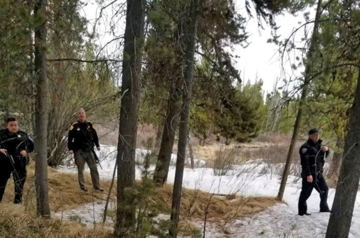 In this photo provided by the Gallatin County Sheriff's Office, officers from the sheriff's office and West Yellowstone Police Department are seen near the scene of a grizzly bear mauling just outside Yellowstone National Park near West Yellowstone, Mont. on April, 15, 2021. Authorities said Charles "Carl" Mock died Saturday of injuries sustained in the attack.