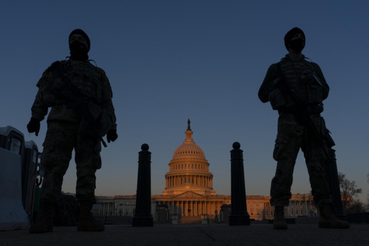 FILE - In this March 8, 2021, file photo, National Guard soldiers stand their posts around the Capitol at sunrise in Washington. Partisan tensions have only gotten worse on Capitol Hill since Pelosi's defiant act last year, days before the Senate acquitted Trump in his first impeachment trial. Since then, the Capitol has been through the Jan. 6 insurrection, another House impeachment and another Senate acquittal.