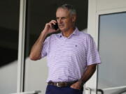 Major League Baseball commissioner Rob Manfred speaks on his phone as he watches a spring training baseball game between the Atlanta Braves and Boston Red Sox on Wednesday, March 10, 2021, in Fort Myers, Fla..