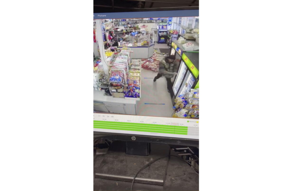 This video provided by Mark Sung shows a man with a pole trashing an Asian-owned convenience store on Tuesday, March 30, 2021 in Charlotte, N.C.  Surveillance footage shows the man pulling a merchandise rack to the floor and swinging a street sign post into the glass on the refrigerators. Charlotte-Mecklenburg Police said a company that&#039;s responsible for security at the transit center arrested Xavier Rashee Woody-Silas. He was arrested on charges that include robbery with a dangerous weapon and communicating threats.