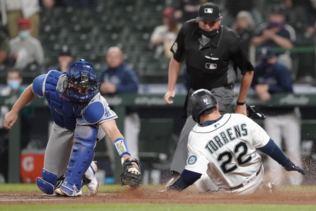 Los Angeles Dodgers second baseman Chris Taylor, right, tries to put a tag on Seattle Mariners' J.P. Crawford, left, as Crawford attempts to steal second during the second inning of a baseball game, Monday, April 19, 2021, in Seattle. Crawford was called out on the play. (AP Photo/Ted S.