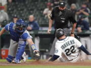 Los Angeles Dodgers second baseman Chris Taylor, right, tries to put a tag on Seattle Mariners' J.P. Crawford, left, as Crawford attempts to steal second during the second inning of a baseball game, Monday, April 19, 2021, in Seattle. Crawford was called out on the play. (AP Photo/Ted S.