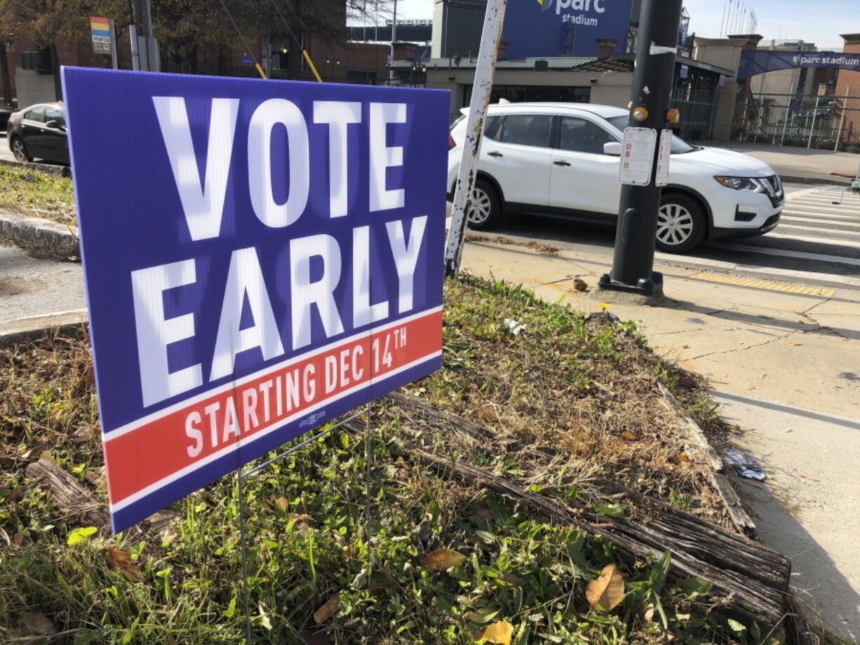 FILE - In this Dec. 11, 2020 file photo, a sign in an Atlanta neighborhood  urges people to vote early in Georgia's two U.S. Senate races.   Republicans are moving to make it harder for that to happen again, potentially affecting the voting preferences for millions of Americans in future elections. The GOP's campaign to place new restrictions on mail-in and early voting in certain states will force voters to contend with new rules on what are popular and proven methods of casting ballots.