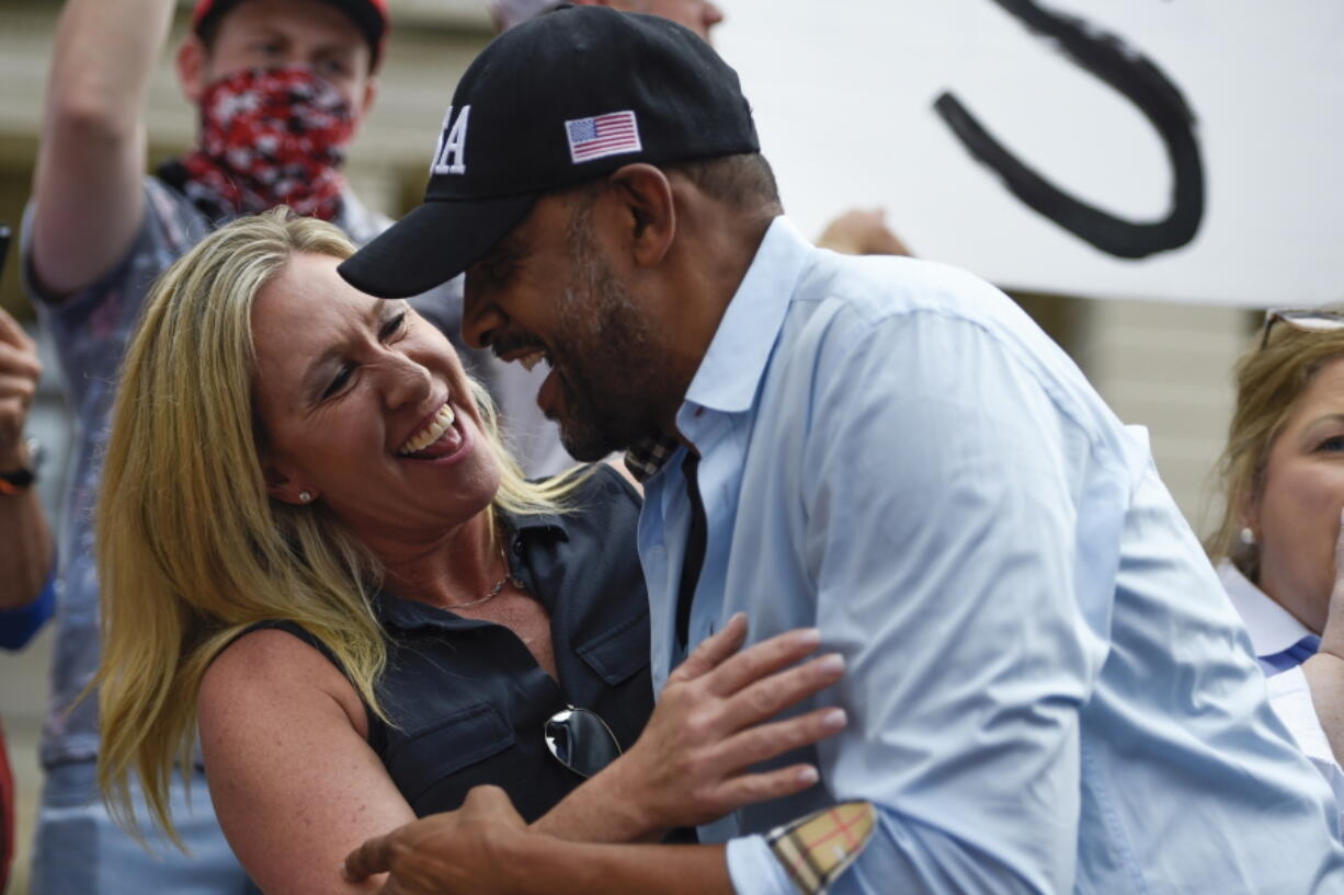 FILE-In this Saturday, Nov. 7, 2020 file photo, president Donald Trump supporters cheer as Georgia State Rep. Vernon Jones and Republican Congresswoman-elect Marjorie Taylor Greene embrace during a rally, at the capital in Atlanta.  Jones is scheduled to announce a challenge for the 2022 Georgia Republican gubernatorial nomination, arguing incumbent Brian Kemp hasn't done enough to support President Donald Trump.