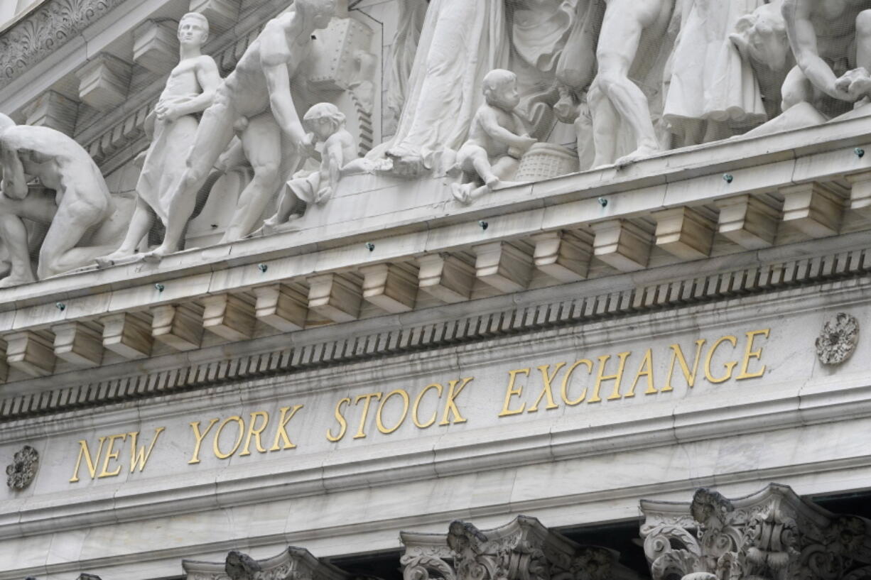 FILE - In this Nov. 23, 2020 file photo, stone sculptures adorn the New York Stock Exchange. Stocks are easing lower in early trading on Wall Street as investors absorb the latest round of company earnings reports. The S&P 500 was off 0.2% in the first few minutes of trading Tuesday, April 20, 2021, pulling further below the record high it set on Friday.