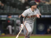 San Francisco Giants&#039; Buster Posey watches his solo home run during the third inning of the team&#039;s baseball game against the Seattle Mariners, Friday, April 2, 2021, in Seattle. (AP Photo/Ted S.