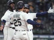 Seattle Mariners&#039; Taylor Trammell, left, greets Dylan Moore (25) at the plate after they scored during the eighth inning of the team&#039;s baseball game against the San Francisco Giants, Thursday, April 1, 2021, in Seattle. (AP Photo/Ted S.