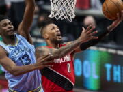 Portland Trail Blazers guard Damian Lillard (0) shoots over Memphis Grizzlies forward Jaren Jackson Jr. (13) during the first half of an NBA basketball game in Portland, Ore., Friday, April 23, 2021.