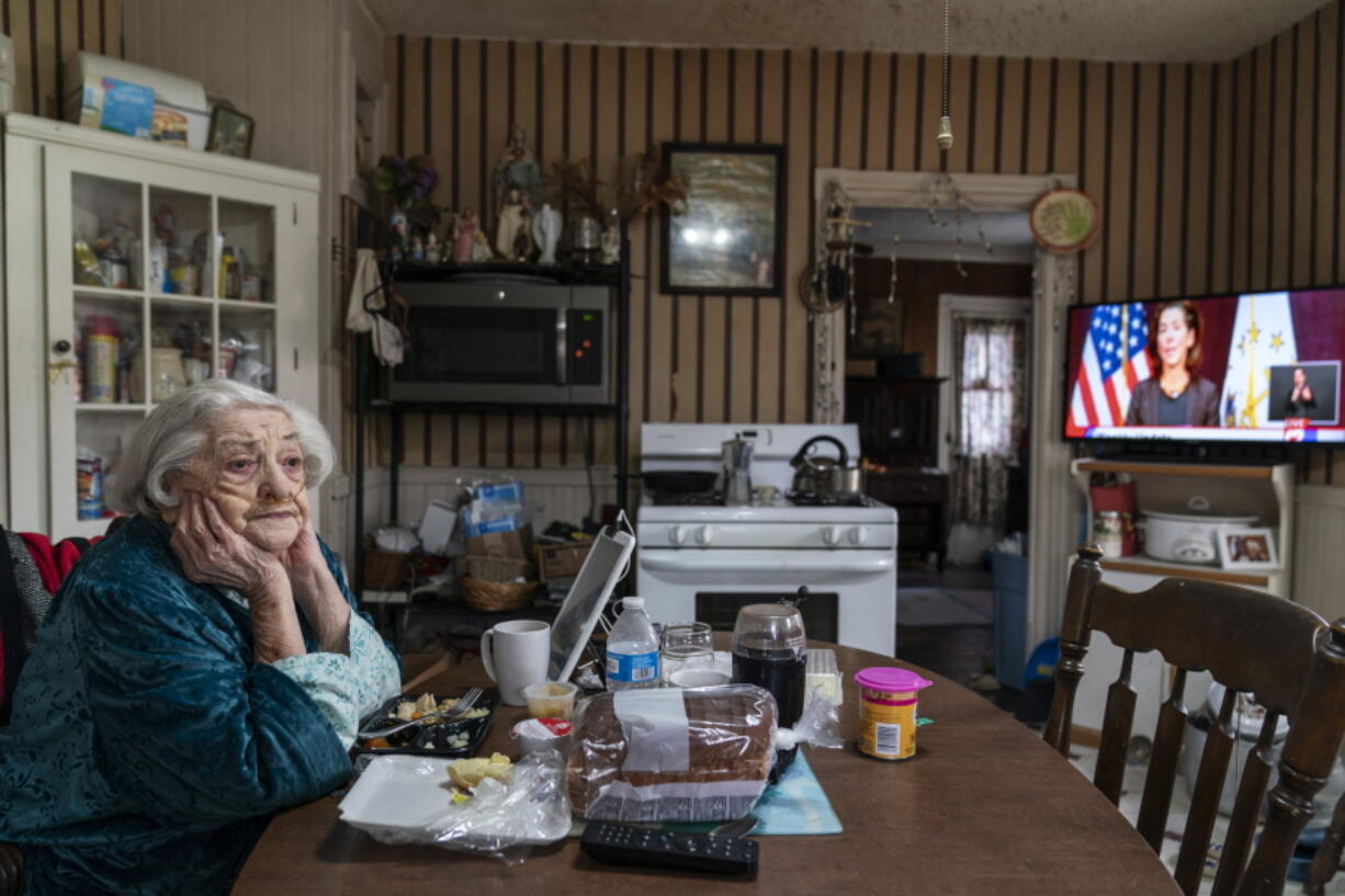 Rita Scanlon, 92, eats lunch delivered to her by Meals on Wheels of Rhode Island as she listens to Gov. Gina Raimondo&#039;s press conference urging residents to stay home for Thanksgiving amid an increase in COVID-19 hospitalizations on Nov. 25 in Central Falls, R.I. Meals on Wheels of Rhode Island has been delivering on average 4,000 meals per day, up from their pre-pandemic average of 1,200.