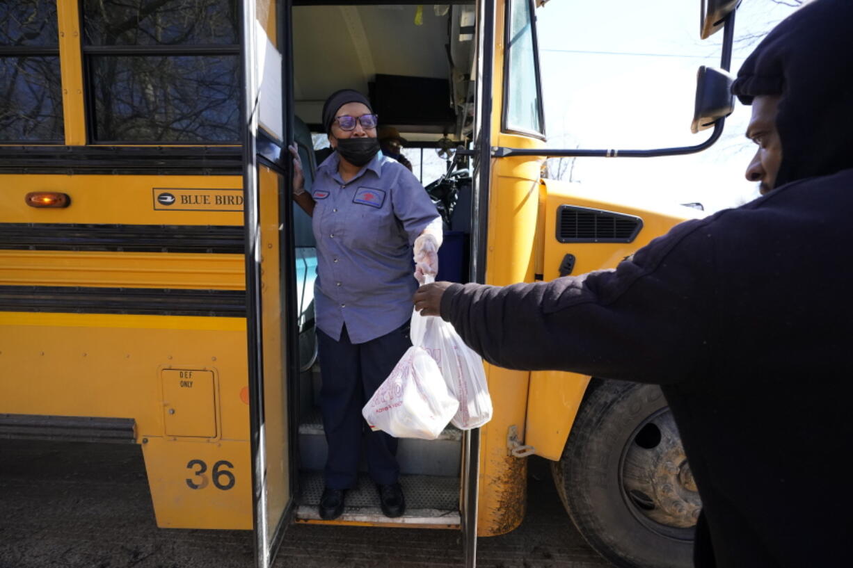 Jefferson County School District Department of Food Services staff member Raquel Mims-Cole, center, hands out several days of bagged lunches to a parent for his children on Wednesday, March 3, 2021 in Fayette, Miss. As one of the nation&#039;s most food insecure counties, free breakfast and lunches are provided to students at school and those at home &quot;virtually learning.&quot; The meals may be the children&#039;s only means of daily sustenance. (AP Photo/Rogelio V.