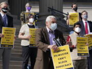 Rev. Graylan Hagler, center, speaks outside the National City Christian Church in Washington, Monday, April 5, 2021. A coalition of interfaith leaders and activists met in Washington and online to demand an end to the filibuster, calling it an arcane and racist tactic that blocks the passing of moral policies.