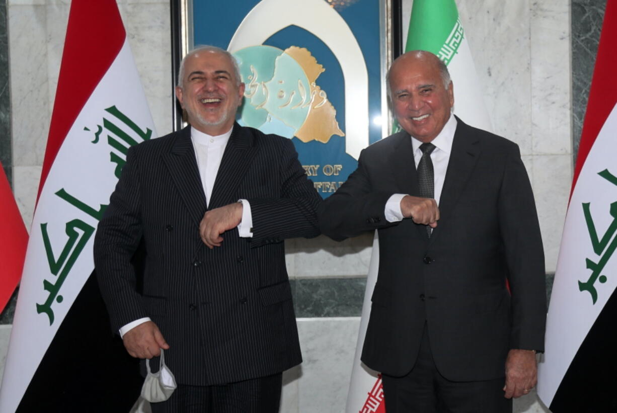 Iraqi Foreign Minister Fouad Hussein, right, meets with visiting Iranian counterpart Mohammad Javad Zarif in Baghdad, Iraq, Monday, April 26, 2021.