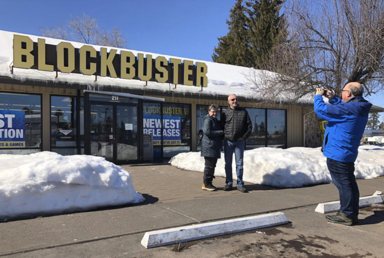 Debby Saltzman, of Bend, Ore., poses in front of the last Blockbuster store with her twin brother, Michael, visiting from Australia, in Bend in March 2019. Taking the photo is Saltzman&#039;s husband, Jeremy Saltzman. A new Netflix movie that began airing March 15 is generating interest in the store.