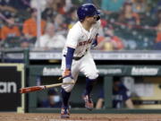 Houston Astros' Jose Altuve flips his bat as he watches his two-run RBI single against the Seattle Mariners during the fourth inning of a baseball game Monday, April 26, 2021, in Houston. This game is the return to play for Altuve after being diagnosed with COVID-19.