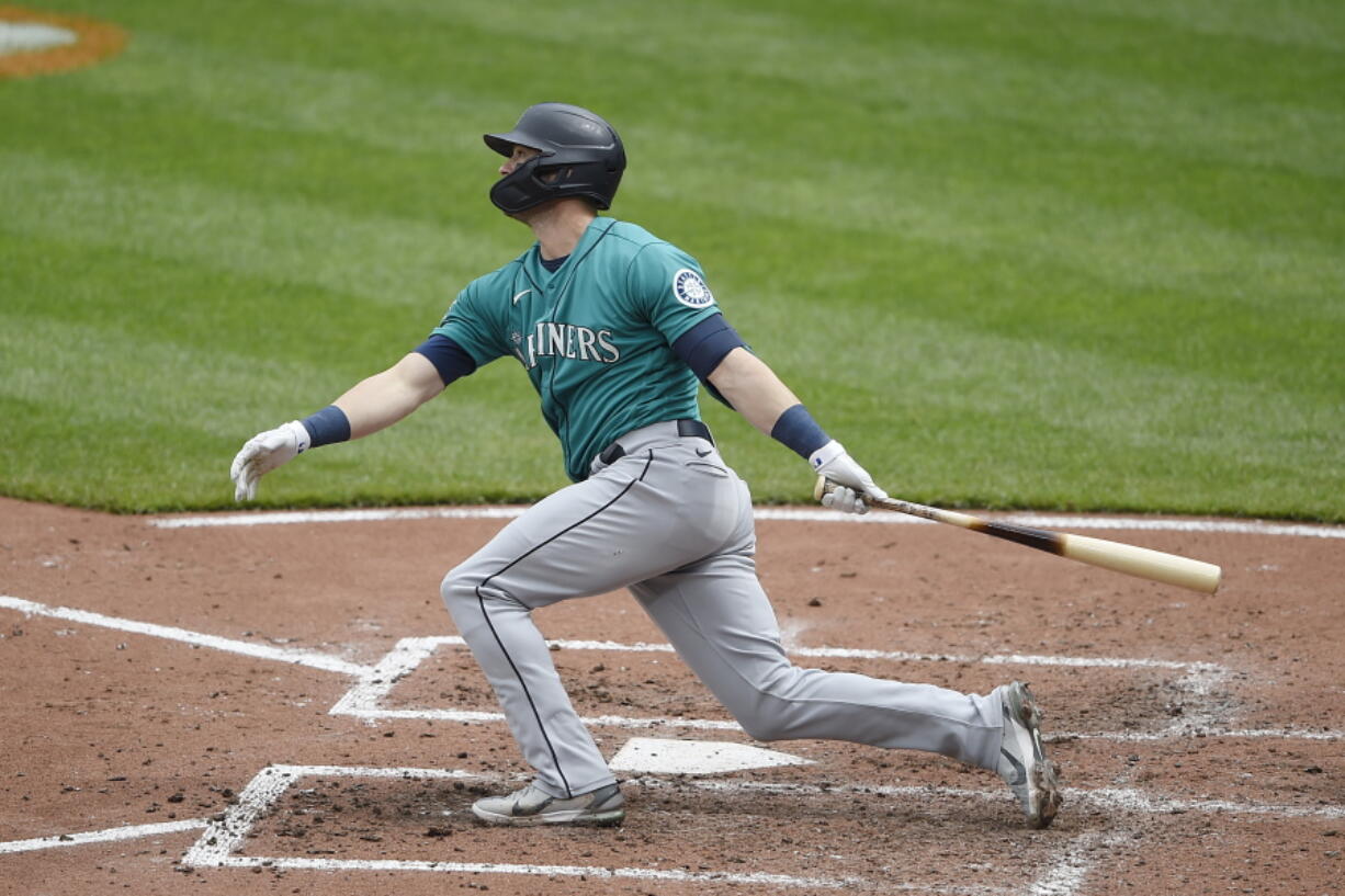 Seattle Mariners' Mitch Haniger follows through on a two run home run against the Baltimore Orioles in the fifth inning of the first game of a baseball doubleheader, Thursday, April 15, 2021, in Baltimore.