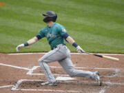 Seattle Mariners' Mitch Haniger follows through on a two run home run against the Baltimore Orioles in the fifth inning of the first game of a baseball doubleheader, Thursday, April 15, 2021, in Baltimore.