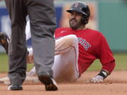 Boston Red Sox's J.D. Martinez is safe at second base after hitting a double off a pitch by Seattle Mariners' Ljay Newsome in the seventh inning of a baseball game, Sunday, April 25, 2021, in Boston.