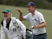 Justin Rose and his caddie David Clark react to his second shot on the eighteenth hole during the first round of the Masters golf tournament at Augusta National Golf Club, Thursday, April 8, 2021, in Augusta, Ga.