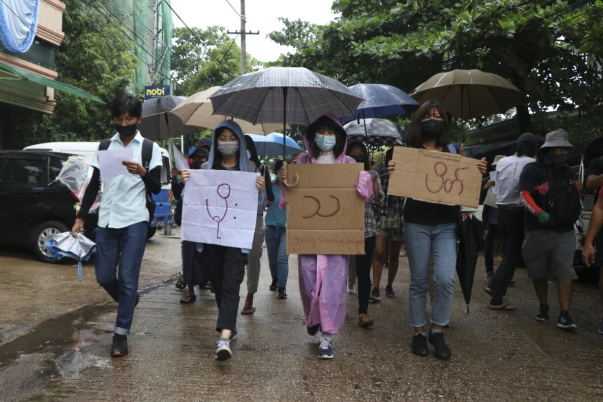 Anti-coup protesters hold slogans which read &quot;Rain Strike&quot; as they use their umbrellas during a drizzle while participating in a demonstration in Yangon, Myanmar on Tuesday April 6, 2021. Threats of lethal violence and arrests of protesters have failed to suppress daily demonstrations across Myanmar demanding the military step down and reinstate the democratically elected government.