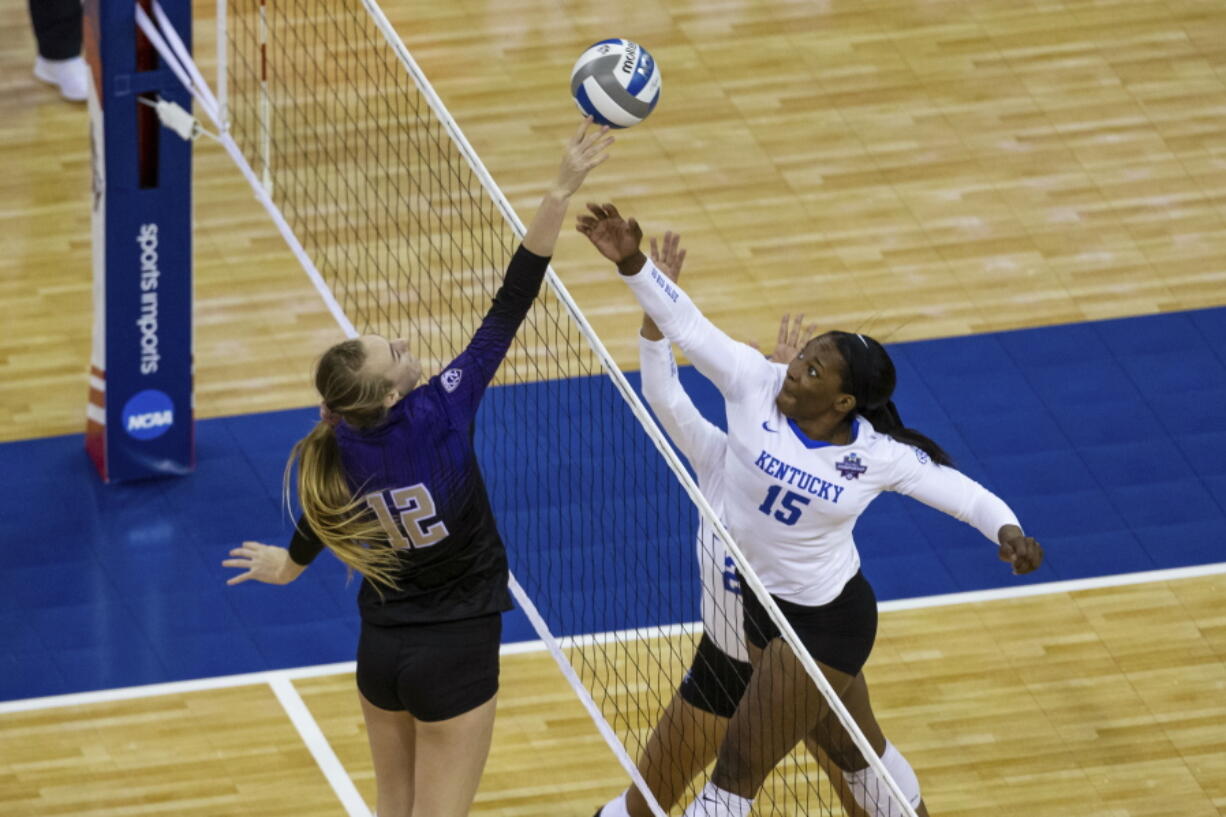 Washington's Marin Grote (12) bumps the ball over Kentucky's Azhani Tealer (15) during the first set of a semifinal in the NCAA women's volleyball championships Thursday, April 22, 2021, in Omaha, Neb.