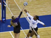 Washington's Marin Grote (12) bumps the ball over Kentucky's Azhani Tealer (15) during the first set of a semifinal in the NCAA women's volleyball championships Thursday, April 22, 2021, in Omaha, Neb.