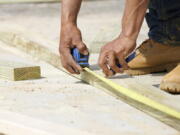 A beam is measured and marked March 16 at a housing site in Madison County, Miss. After a year of spending more time at home due to the COVID-19 pandemic, homeowners are looking to adapt their spaces to their new realities. In 2021, expect to see more interest in creating dedicated spaces within the home. (Rogelio V.