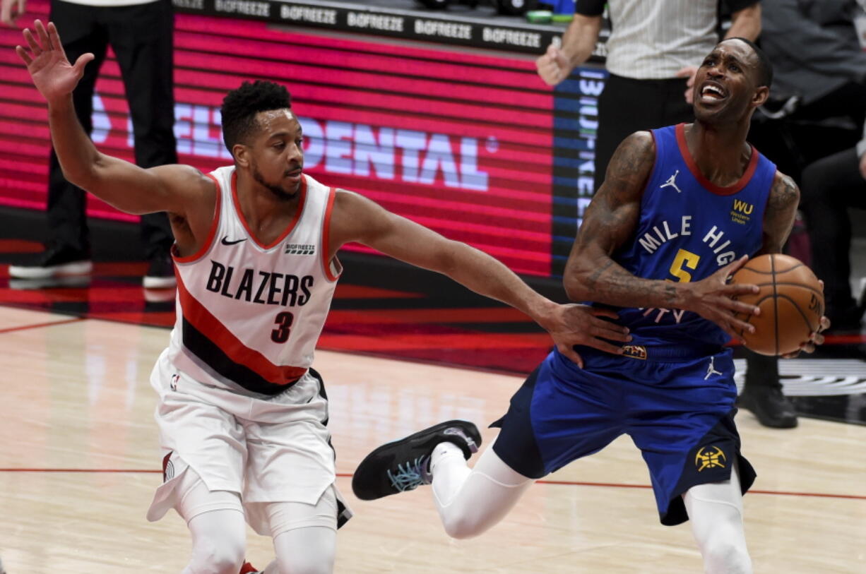 Portland Trail Blazers guard CJ McCollum, left, fouls Denver Nuggets forward Will Barton during the first half of an NBA basketball game in Portland, Ore., Wednesday, April 21, 2021.