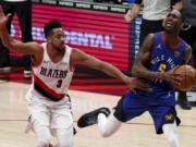 Portland Trail Blazers guard CJ McCollum, left, fouls Denver Nuggets forward Will Barton during the first half of an NBA basketball game in Portland, Ore., Wednesday, April 21, 2021.