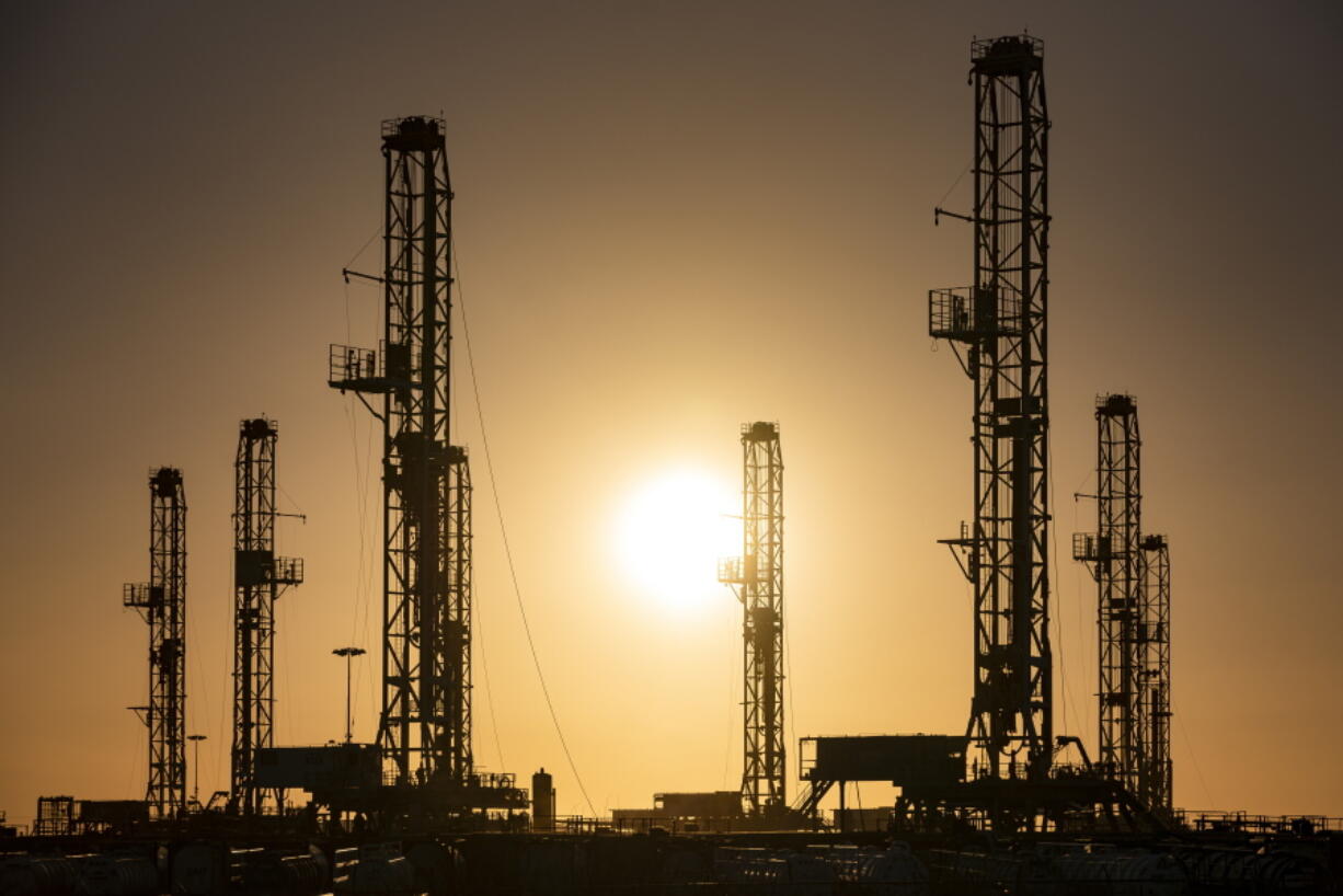 The morning sun rises behind oil rigs sitting in storage Saturday, Feb. 6, 2021 at a yard outside of Odessa, Texas. The OPEC oil cartel and allied countries said Thursday, April 1, 2021 that they have decided to add gradually add back some 2 million barrels per barrel per day of oil production from May to July, moving cautiously in pace with the recovery of the global economy from the COVID-19 pandemic.