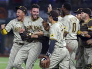 San Diego Padres starting pitcher Joe Musgrove, second from left, is mobbed by teammates after pitching a no-hitter against the Texas Rangers in a baseball game Friday, April 9, 2021, in Arlington, Texas. (AP Photo/Richard W.