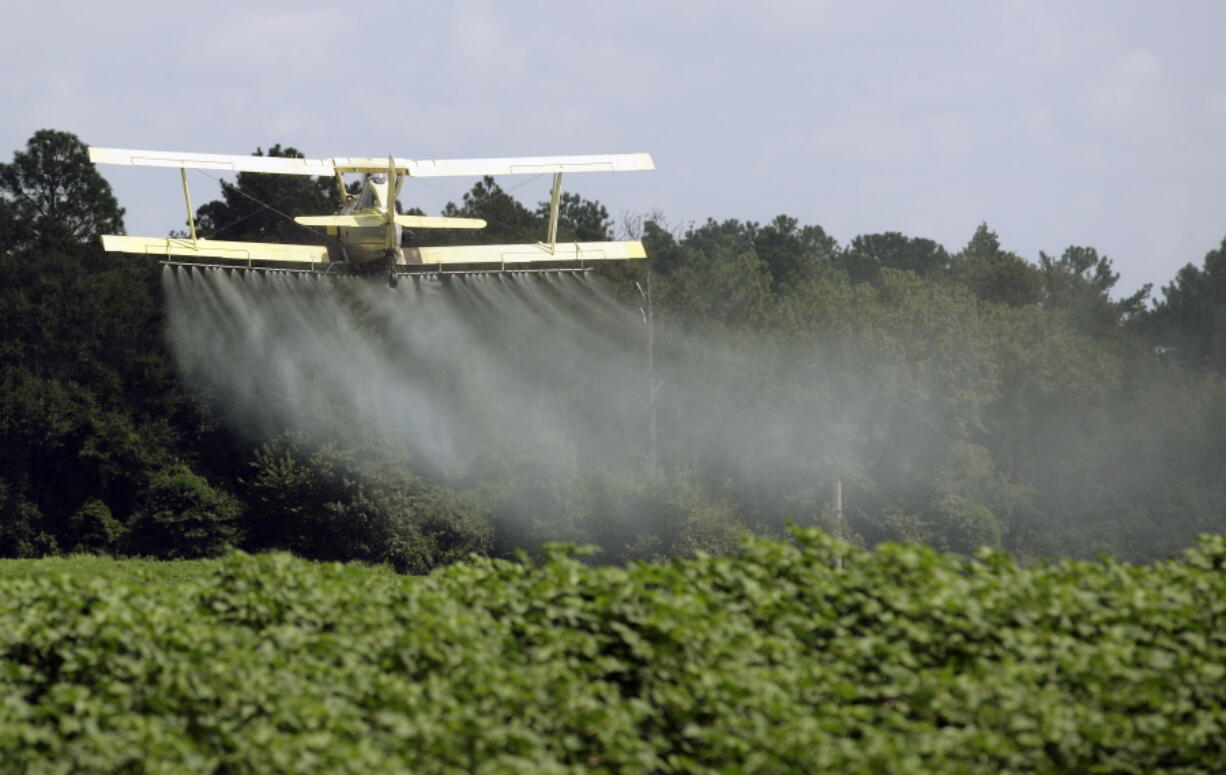 FILE - In this Aug. 4, 2009 file photo, a crop duster sprays a field in Alabama. A study published in the journal Science on Thursday, April 1, 2021 finds that farmers in the U.S. are using smaller amounts of better targeted pesticides, but these are harming pollinators, aquatic insects and some plants far more than decades ago.