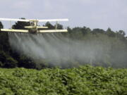 FILE - In this Aug. 4, 2009 file photo, a crop duster sprays a field in Alabama. A study published in the journal Science on Thursday, April 1, 2021 finds that farmers in the U.S. are using smaller amounts of better targeted pesticides, but these are harming pollinators, aquatic insects and some plants far more than decades ago.