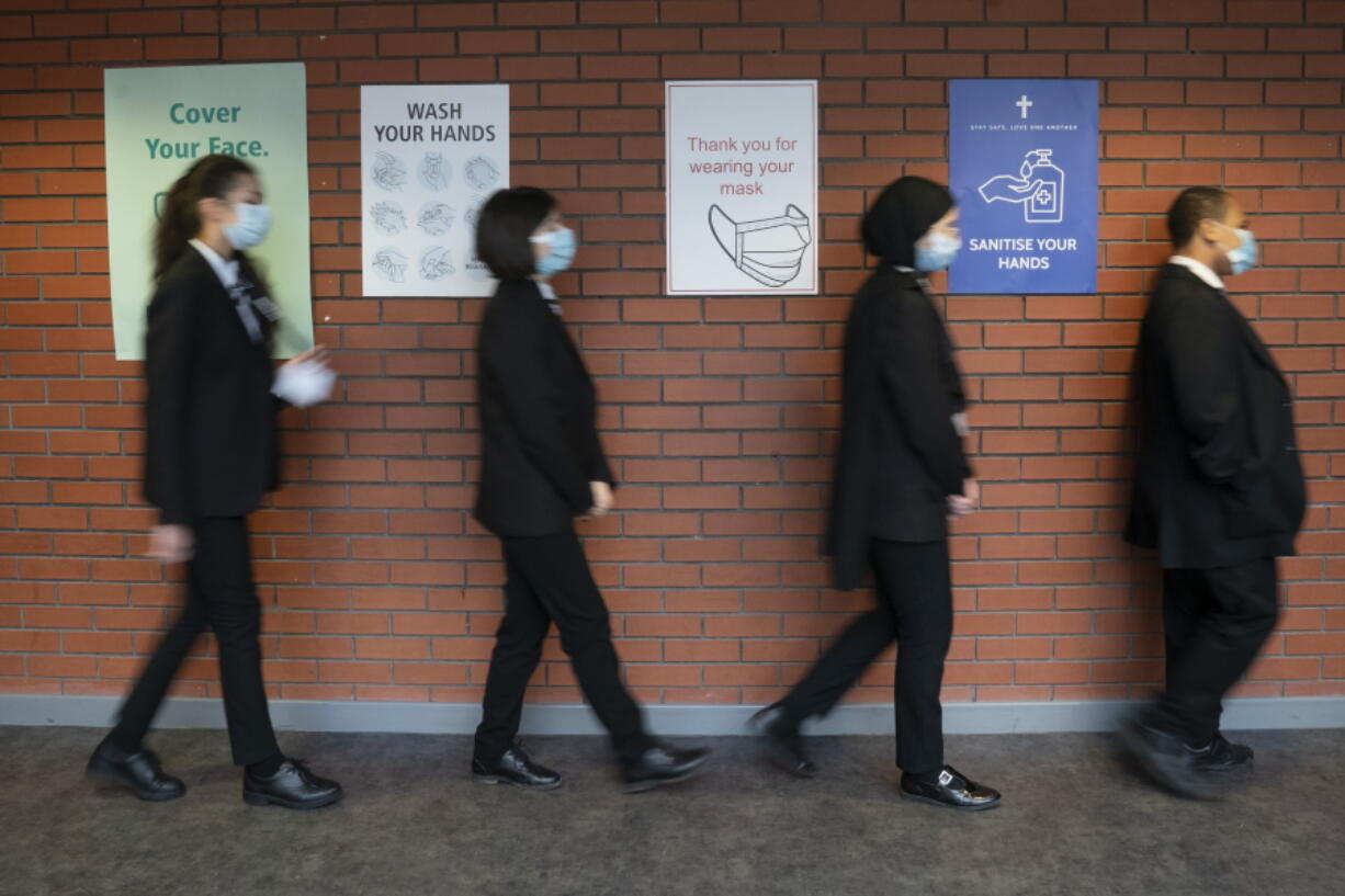 FILE - In this Monday, March 8, 2021 file photo, pupils queue for a socially distanced assembly at a school in in Manchester, England.  Pfizer and BioNTech have submitted a request to the European drug regulator for the approval of their coronavirus vaccine to be extended to include children aged 12 to 15 years old, in a move that could offer younger and less at-risk populations in Europe access to the shot for the first time.