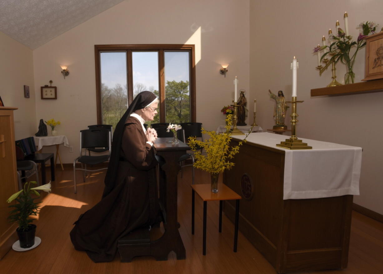 The Rev. Sister Barbara Smith, of the Order of Discalced Carmelites, prays on a prayer bench that belonged to The Rev. Mychal Judge, the Fire Department of New York&#039;s chaplain who died in the 2001 attacks on the World Trade Center, at the Episcopal Carmel of Saint Teresa in Rising Sun, Md., on Sunday, April 4, 2021. The Episcopal Carmel of Saint Teresa donated the prayer bench to the National Sept. 11 Memorial and Museum, representatives of which acquired the bench later in the morning.