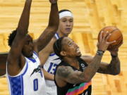 San Antonio Spurs forward DeMar DeRozan, right, looks for a shot against Orlando Magic&#039;s Robert Franks (0) and guard R.J. Hampton, back center, during the second half of an NBA basketball game, Monday, April 12, 2021, in Orlando, Fla.