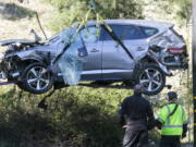 FILE - In this Feb. 23, 2021, file photo, a crane is used to lift a vehicle following a rollover accident involving golfer Tiger Woods, in the Rancho Palos Verdes suburb of Los Angeles. The Los Angeles County sheriff plans to announce Wednesday, April 7, 2021, what caused Woods to crash an SUV in Southern California earlier in the year, seriously injuring himself in the wreck. (AP Photo/Ringo H.W.