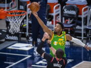 Utah Jazz guard Donovan Mitchell (45) lays the ball up while guarded by Portland Trail Blazers center Jusuf Nurkic (27) during the first half of an NBA basketball game Thursday, April 8, 2021, in Salt Lake City.